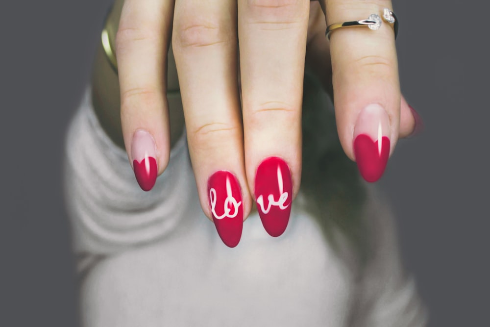 Red nail art with love script