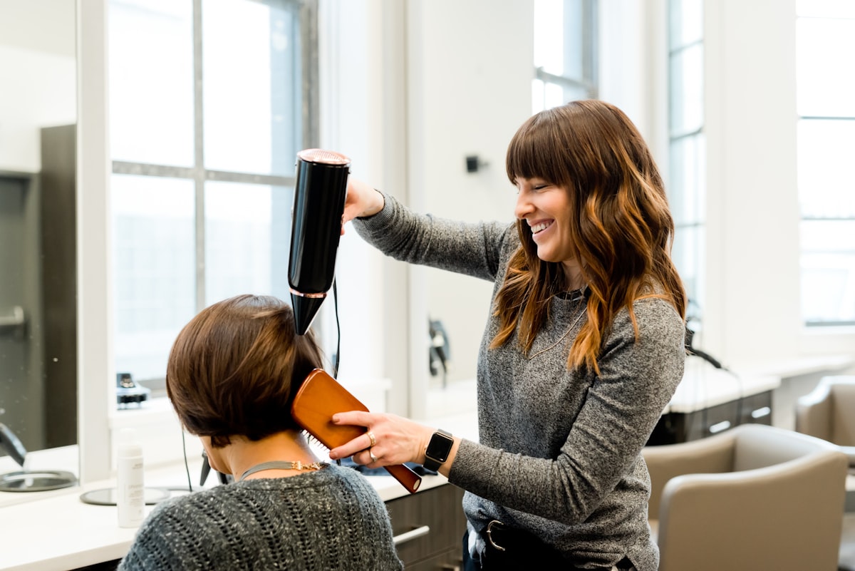 Stylist blow-drying a client's hair at One Touch Salon